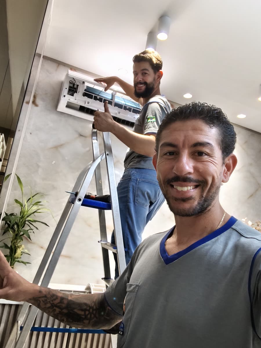 Equipe da Águia Ar Condicionado higienizando um split em Maringá, com o aparelho aberto